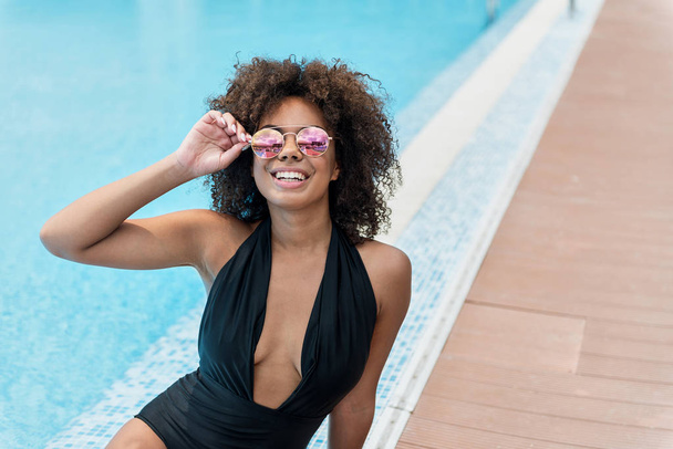 Happy youthful african lady taking tan on resort - Foto, immagini