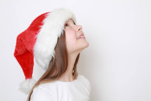 Teen girl in Santa hat posing on camera - Фото, зображення