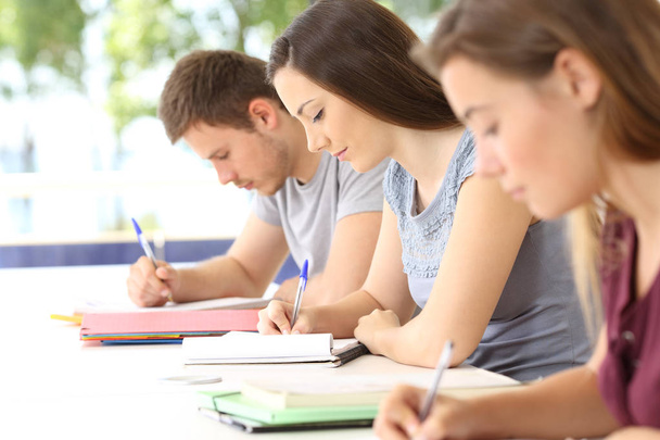 Three students taking notes during a class - Foto, imagen