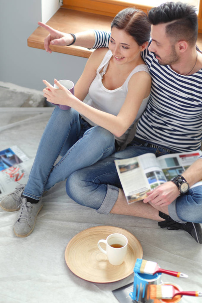 Couple moving in house sitting on the floor . Couple - Фото, изображение