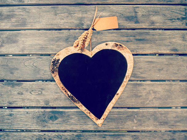 Panneau craie en forme de coeur sur mur en bois, couleur vintage filtrée
 - Photo, image
