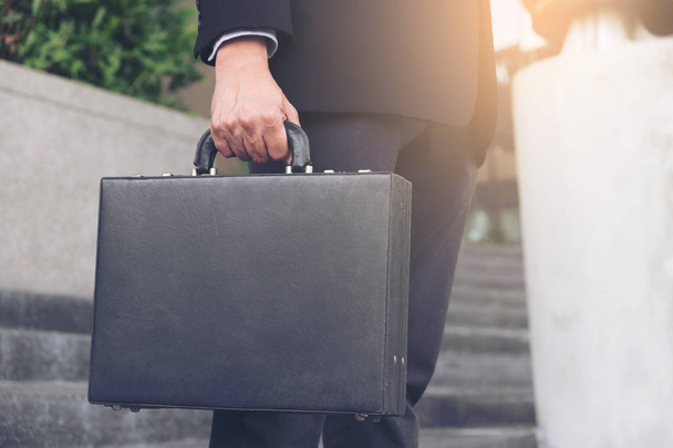 Businessman standing and holding a briefcase in hand working wit - Photo, image