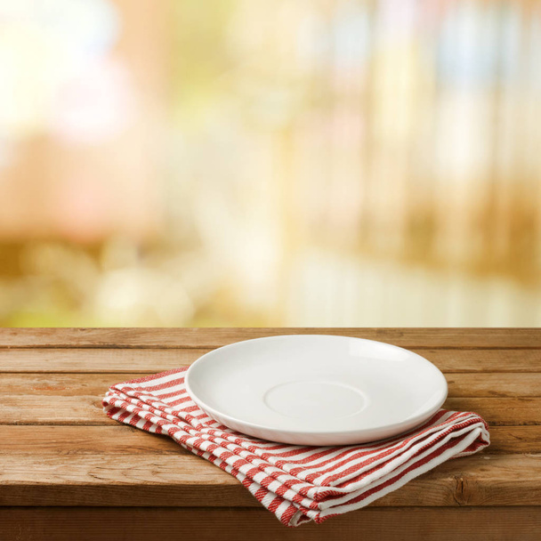 Empty white plate on wooden table - Fotó, kép