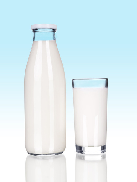 Full Bottle of fresh milk and one glass on a blue background - Fotó, kép