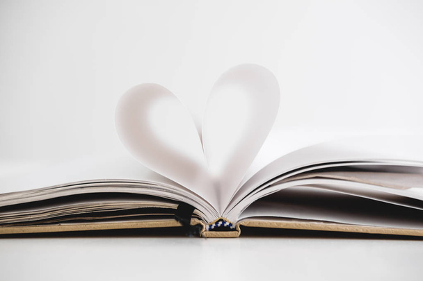Heart shape on opened notebook page, on white background - Photo, image