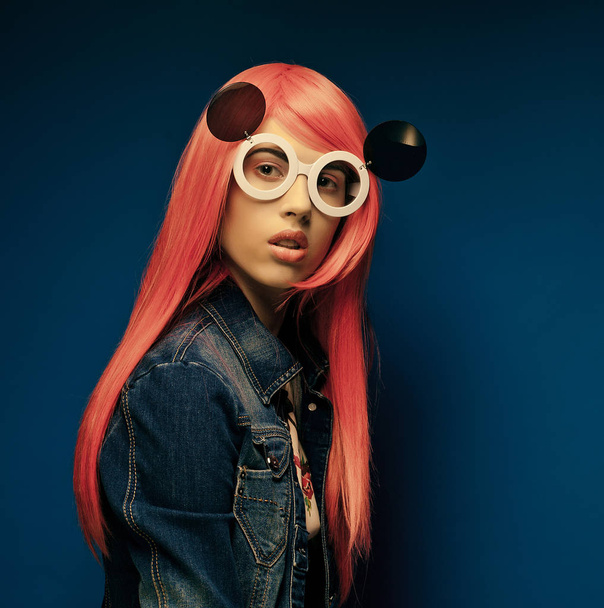 fashion girl with pink hair and big sunglasses over blue  background - Valokuva, kuva