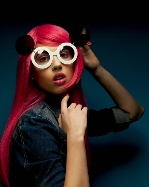 fashion model with pink hair and big sunglasses over blue  background - Foto, immagini