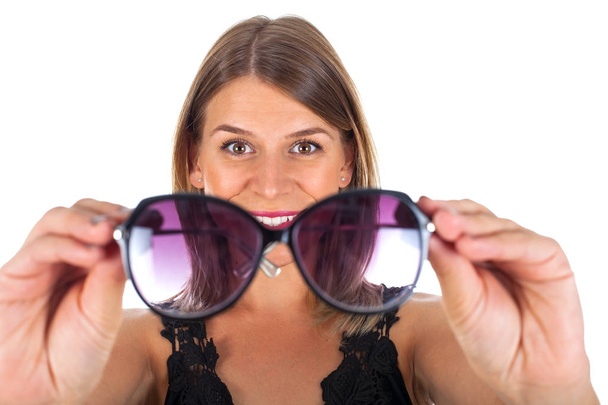 Attractive woman holding her sunglasses - isolated - Photo, Image