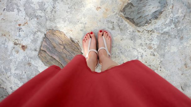 Close Up on Girl's Feet Wearing Sandals and Red Nail on The Cement - Photo, image