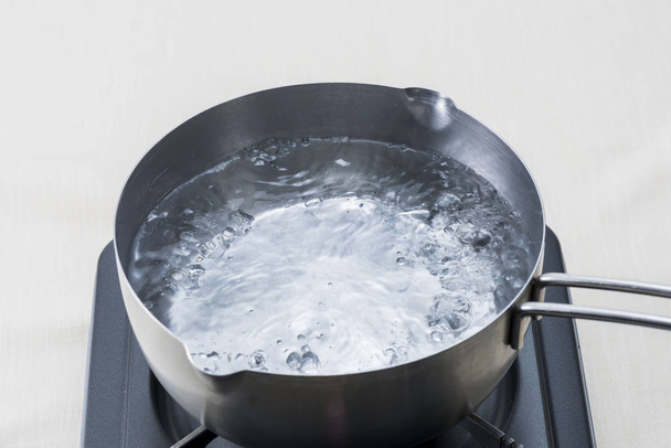 Pot water koken met een gasfornuis - Foto, afbeelding