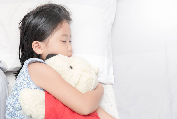 aranyos kis ázsiai lány alvás és ölelés baba  - Fotó, kép