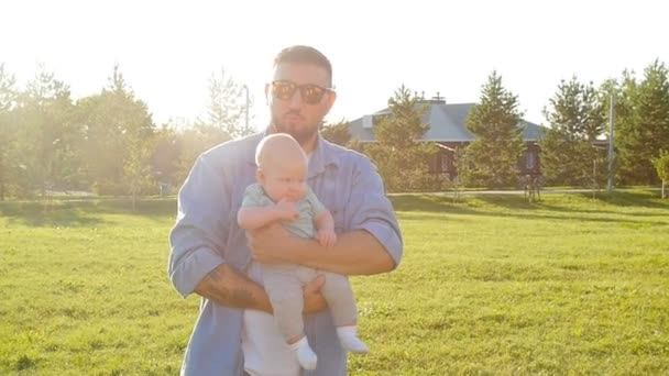 Feliz padre sosteniendo a su hijo al atardecer
 - Metraje, vídeo