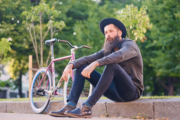 Varón tatuado barbudo con bicicleta
  - Foto, Imagen