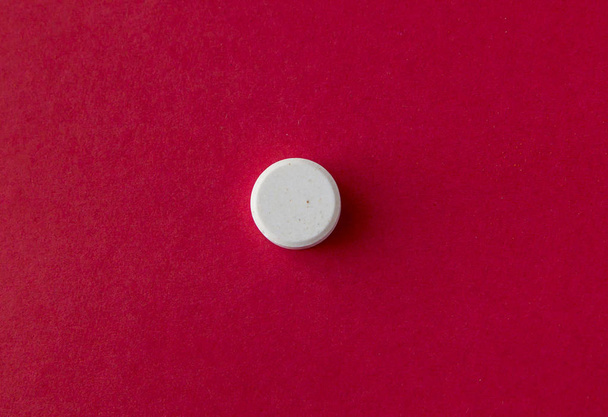 One large tablet on red background. Top view.  - Foto, afbeelding