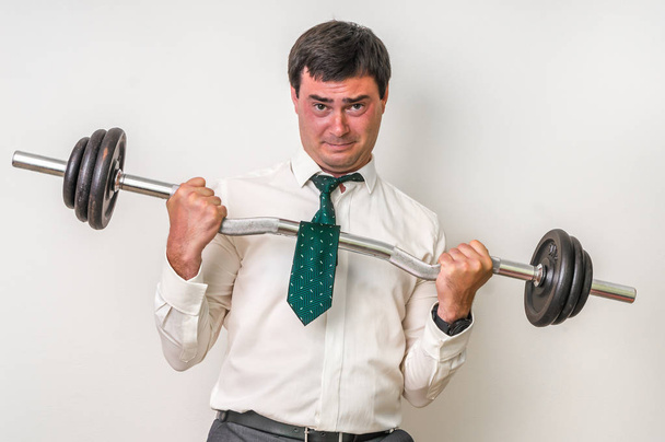 Businessman with barbell is lifting heavy weight - Fotografie, Obrázek