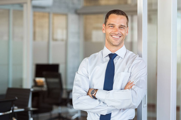 Smiling businessman at office - Фото, изображение