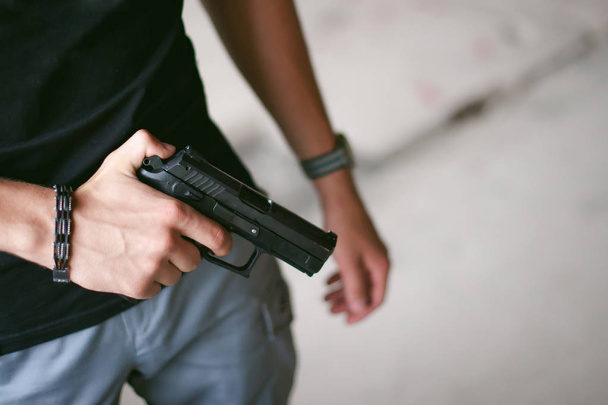 holds a pistol in his hand - Valokuva, kuva