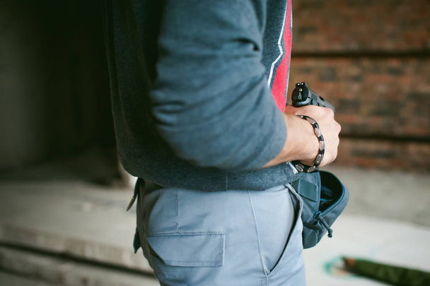 man pulls a gun out of his bag, holding it in his hand - Foto, immagini