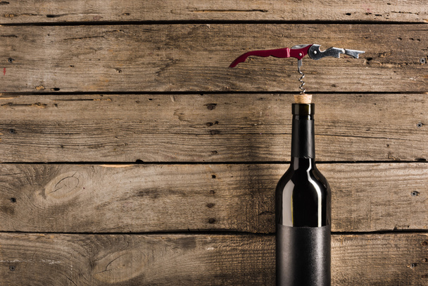 bottle of red wine and corkscrew - Фото, изображение