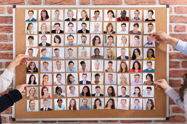 Close-up Of Business People Hiring The Candidates Attached On Corkboard For Job - 写真・画像