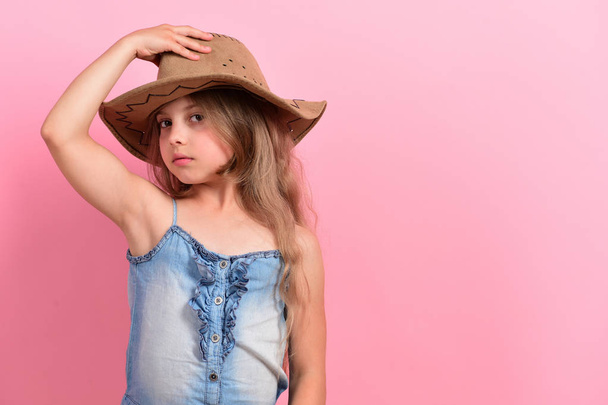 Kid with interested face and long hair wears jeans dress - 写真・画像