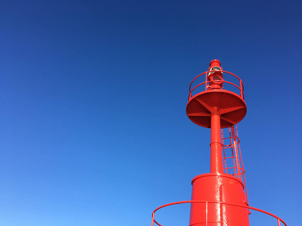 Червоний маяк всередині в порту з синього неба - Фото, зображення