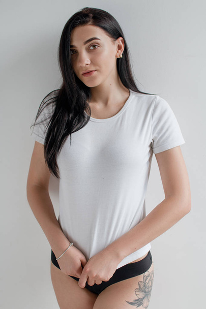 Krásná brunetka v černém prádle a v bílé košili v jasné místnosti - Fotografie, Obrázek