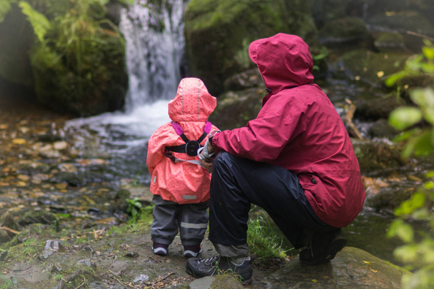 Viaje en familia a la naturaleza: padre y una niña observando el agua
 - Foto, imagen