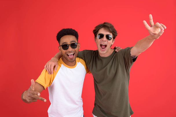 Young two men friends isolated over red background - Foto, Imagen
