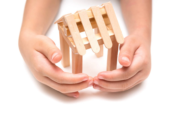 manos de los niños que rodean a un modelo de casa sobre un fondo blanco
 - Foto, Imagen