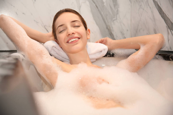 woman relaxing in bath with foam - Foto, afbeelding