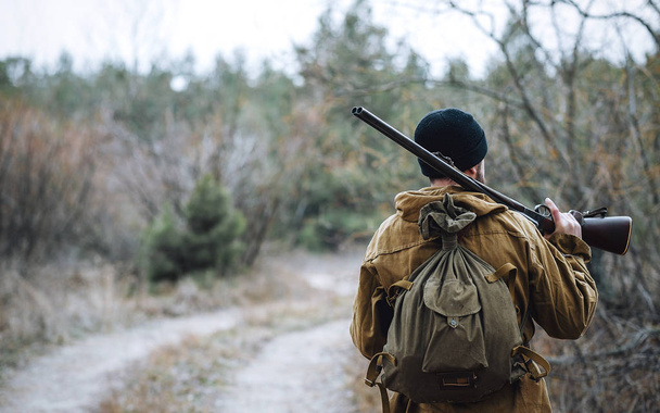 Bebaarde hunter met professionele apparatuur, wandelen in het bos - Foto, afbeelding