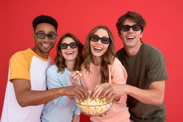 Happy group of friends watching film eating popcorn. - Foto, afbeelding