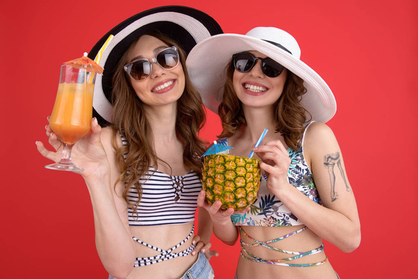 Happy two women drinking cocktails. - Zdjęcie, obraz