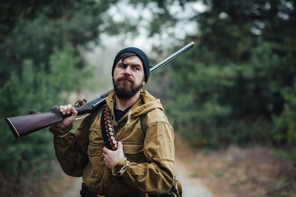 Bearded hunter with professional equipment walking in the woods - Fotoğraf, Görsel