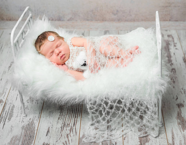 beautiful newborn on white cot with fluffy plaid - 写真・画像