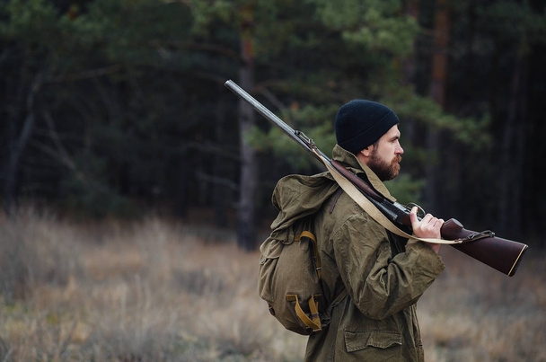 Chasseur barbu avec équipement professionnel marchant dans les bois
 - Photo, image