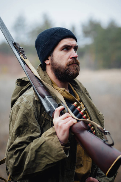 Bearded hunter with professional equipment walking in the woods - Φωτογραφία, εικόνα