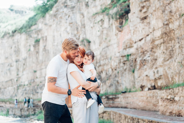 The family standing near a rock wall - 写真・画像