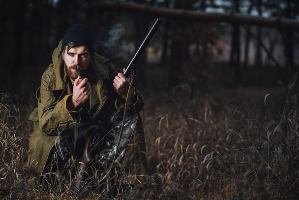 Cacciatore barbuto con attrezzatura professionale che cammina nei boschi
 - Foto, immagini