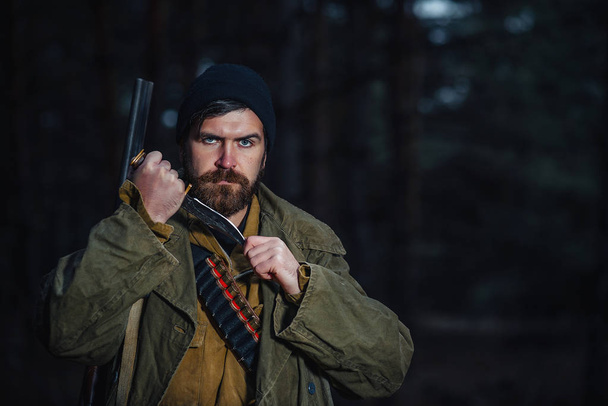 Bearded hunter with professional equipment walking in the woods - Фото, изображение