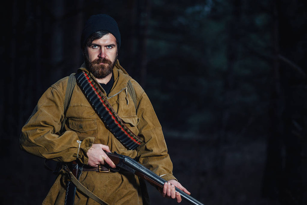 Bearded hunter with professional equipment walking in the woods - Φωτογραφία, εικόνα