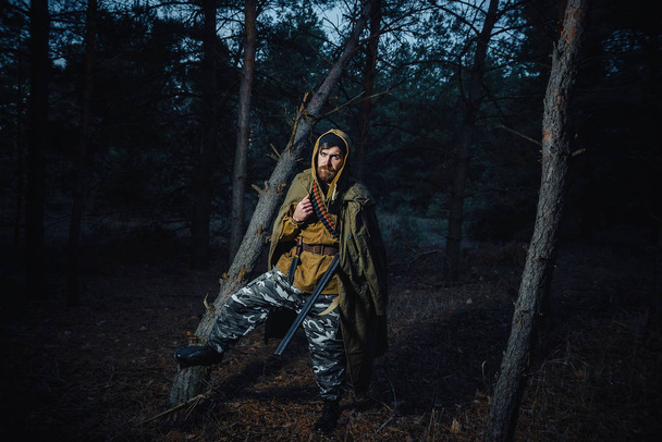 Cazador barbudo con equipo profesional caminando por el bosque
 - Foto, imagen