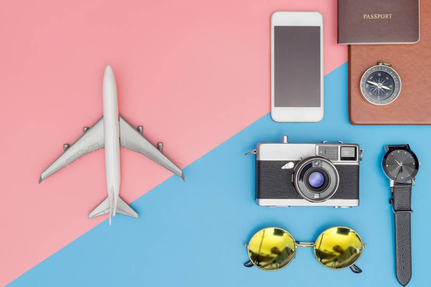 Speelgoed vliegtuig reizen objecten op de op blauwe en roze pastel achtergrond - Foto, afbeelding