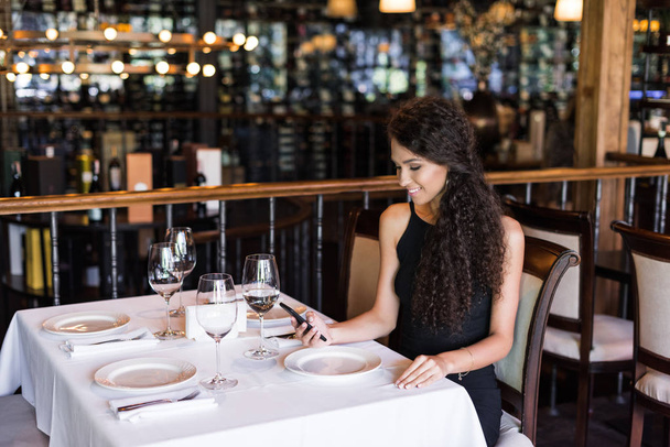 woman using smartphone in restaurant - Photo, Image