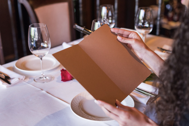Vrouw met menu in restaurant - Foto, afbeelding