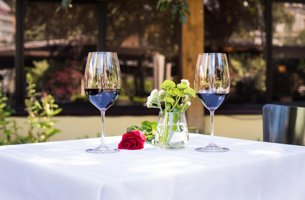růžový květ s vínem u stolu v restauraci - Fotografie, Obrázek