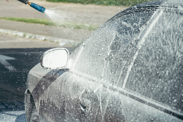 lavage de voiture à la main en utilisant une préparation de mousse pour le polissage, voitures dans un lavage de voiture
 - Photo, image