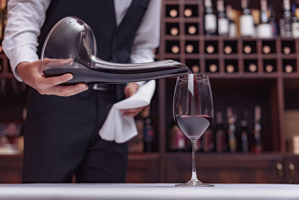 sommelier pouring red wine - Foto, afbeelding