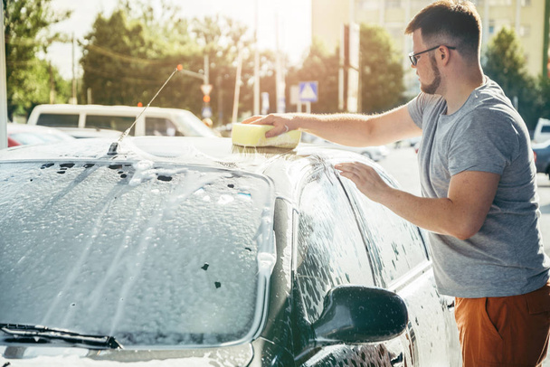 man woshing his car with sponge - Fotó, kép